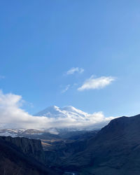 Scenic view of mountains against blue sky