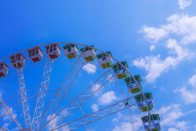 Low angle view of ferris wheel against blue sky