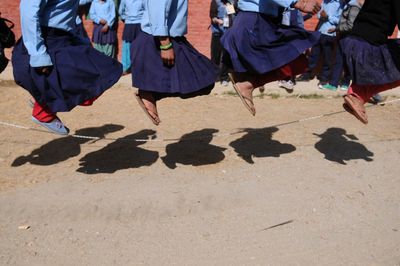 Low section of girls playing over ropes on field