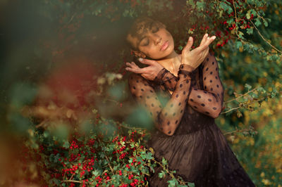 Full length of woman holding flowering plants