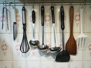 Close-up of spatulas hanging on wall
