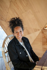 Happy latin woman smiling while sitting indoors.