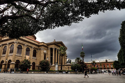 Buildings in city against cloudy sky