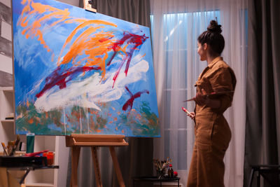 Woman looking at painting at home