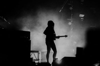 Silhouette man playing guitar at music concert