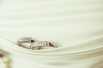 Close-up of wedding rings in white textile
