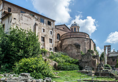 Low angle view of historical ruins of the roman forum building against blue sky. rome, italy.