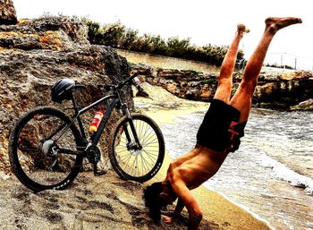 Man with bicycle on sand at beach