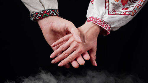 Cropped image of couple holding hands