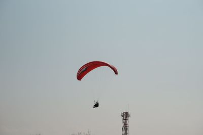 Low angle view of person paragliding against sky