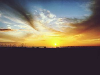 Scenic view of silhouette field against sky during sunset