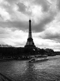 Tower in city against cloudy sky