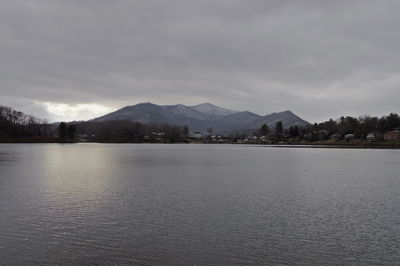 Scenic view of lake by mountains against sky