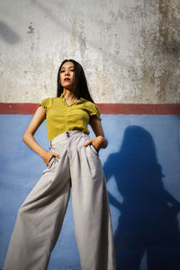 Portrait of woman standing against wall