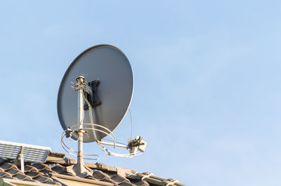 Low angle view of satellite dish on roof against clear sky