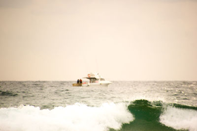 Ship sailing on sea against clear sky
