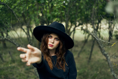 Portrait of young woman wearing hat standing outdoors