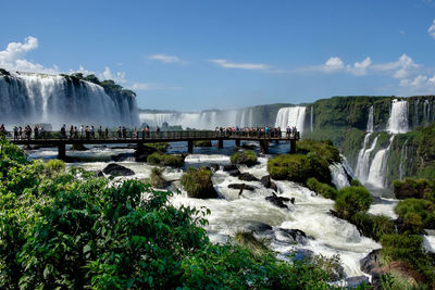 Tourists walking along the boardwalk to view the waterfalls at iguacu on the brazilian side