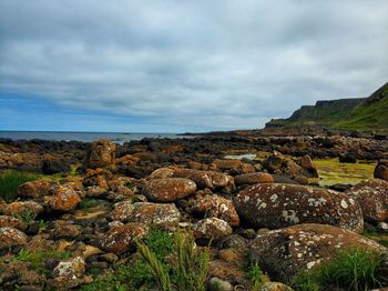 Rocks by sea against sky