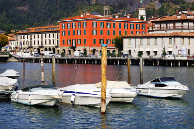 Sailboats moored on canal by buildings in city