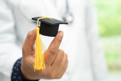Close-up of hand holding mortarboard