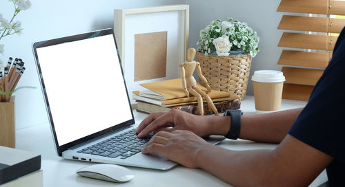 Midsection of woman using laptop on table