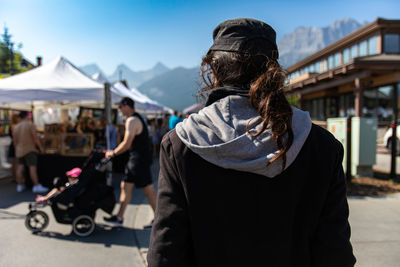 Rear view of woman in market against mountain range