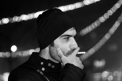 Close-up of man holding illuminated lighting equipment at night