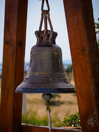 Close-up of rusty metal hanging on tree against sky