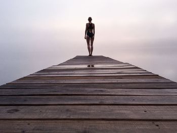 Low angle view of woman standing against sky