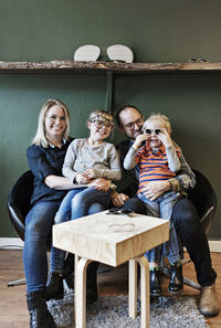 Full length of happy family at eyeglasses workshop