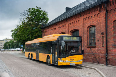 Yellow road by building against sky