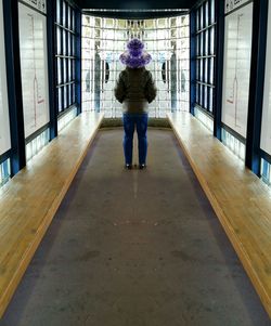 Rear view of man walking in corridor