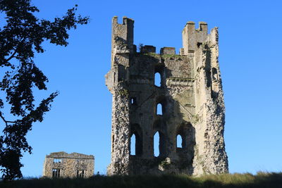 Low angle view of old building against clear blue sky