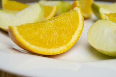 Close-up of orange and apple slices in plate