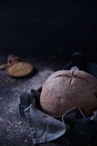 Exposed bread on a dark background, with its ingredients of seeds and flax.