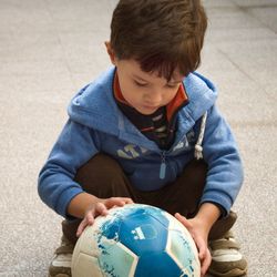 Boy holding football on road