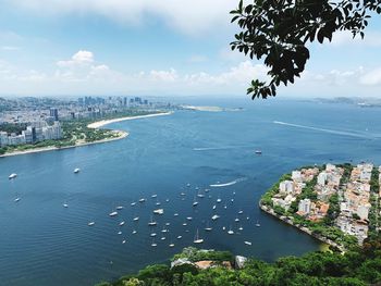 High angle view of city by sea against sky