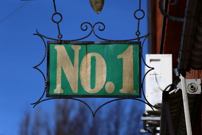 Low angle view of road sign against blue sky