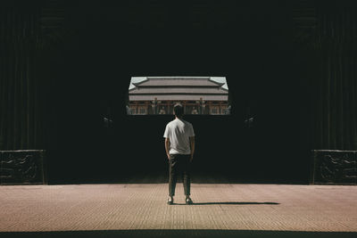 Rear view of man standing against building