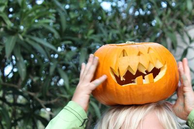 Cropped image of girl holding jack o lantern