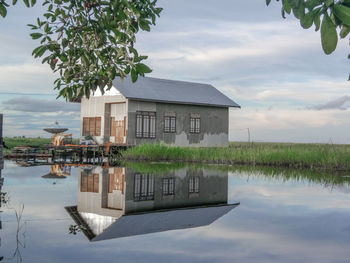 Built structure by lake against sky