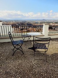 Empty chairs and table against buildings in city