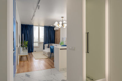 View of the living room with blue curtains and wooden floor