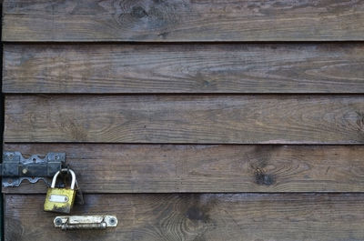 Full frame shot of padlock hanging on wooden door