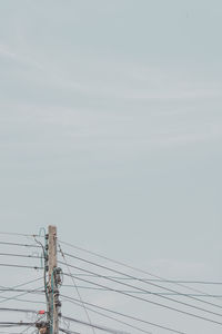 Low angle view of electricity pylon against sky