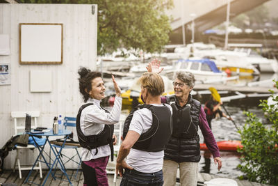 Senior male and female high-fiving on jetty during kayaking course