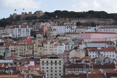 View of cityscape against cloudy sky