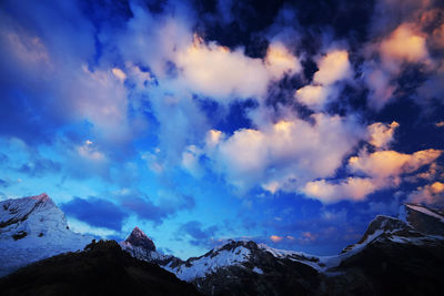 Low angle view of snowcapped mountains against sky 