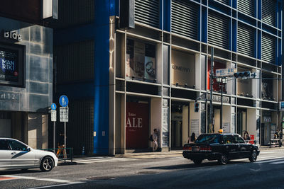 Cars on road by buildings in city